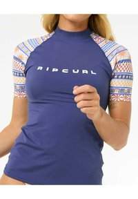 Marineblauwe rash guard met korte mouwen, voorzien van een kleurrijk patroon op de mouwen en het "RIPCURL"-logo in vetgedrukte witte letters.
