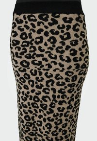 Jupe crayon en tricot à imprimé léopard présentant une base beige avec des taches noires et une taille noire. Texture douce avec un design ajusté.