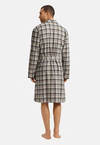 Rutig badrock i beige, blått och krämfärgat med bälte i midjan, långa ärmar, knälång design och mjuk tygtextur.