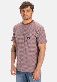 Korte mouw gestreept T-shirt in rood, blauw en wit, met een ronde halslijn en een borstzak met een logo patch. Katoenen stof.