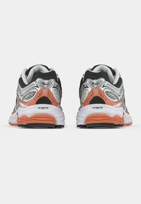 Black and silver athletic shoes with orange accents, mesh upper, cushioned sole, and rubber outsole, viewed from the back.