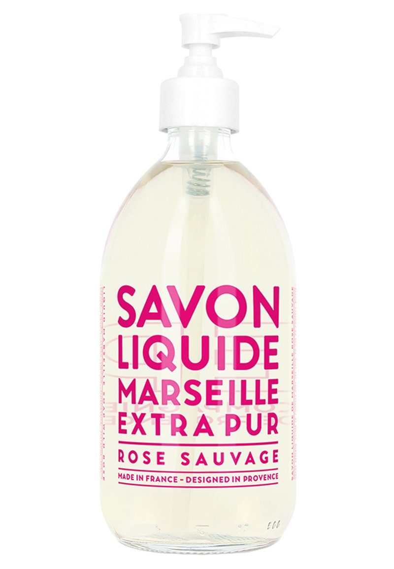 Savon liquide dans une bouteille transparente avec une pompe blanche. L'étiquette présente un texte rose vif avec "Savon Liquide Marseille Extra Pur Rose Sauvage."