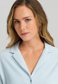 Camicia button-up azzurro chiaro, con texture, colletto e chiusura a un bottone. Presenta un tessuto morbido e una vestibilità su misura per un aspetto ordinato.