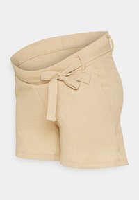 Beige shorts laget av teksturert stoff, med belte i livet og sidelommer. Designet er avslappet med en lett buet søm.