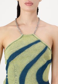 Top halter verde e blu a fantasia con spallina in catena, realizzato in un tessuto testurizzato, caratterizzato da una silhouette aderente e da un design a onde unico.