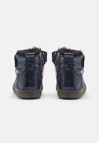 Mörkblå ankla stövlar med en glänsande, texturerad yta, prydda med fuskpäls och lila detaljer. Fästa med kardborrband.