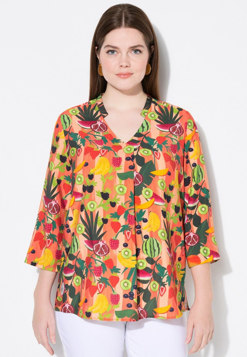 Farverig kortærmet bluse med levende frugtmønstre, v-hals design, i nuancer af orange, grøn og rød, med en løs pasform.