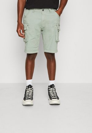 Light green cargo shorts with multiple side pockets, an integrated belt loop, and a slightly distressed texture, paired with black high-top sneakers.