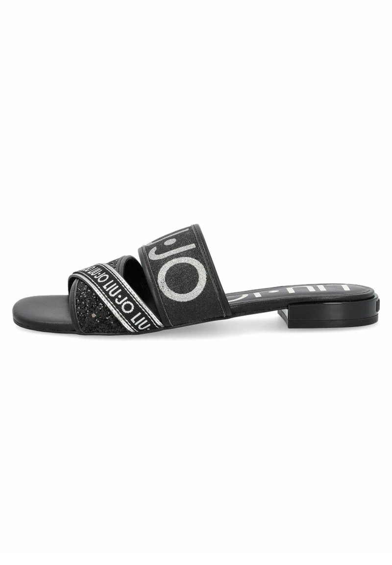 Schwarze Rutsch-Sandalen mit zwei strukturierten Riemen, von denen einer mit Glitzer und der andere mit einem Logo-Print versehen ist. Flache Sohle mit minimalem Absatz.