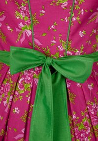 Šaty s květinovým vzorem vyrobené z jasně růžové bavlny s páskem z zelené látky. Obsahují nařasené sklady a mašličku vzadu.