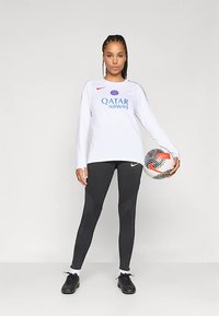 Valge pika varrukaga särk punase Nike logoga ja tekstiga „Qatar Airways“. Mustad tekstuuriga retuusid. Must jalgpall punaste ja valgete aktsentidega.