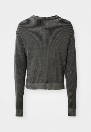 Svart ribbestrikket genser med lange ermer, rund hals og cropped design. Har teksturert stoff og subtile frayed kanter nederst.