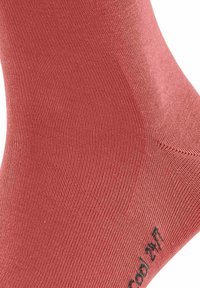 Socken aus Baumwollmischung in Korallenfarbe mit geripptem Textur, ausgestattet mit verstärkter Ferse und Zehen. Mit dem Etikett "Cool 27" in der Nähe des Knöchels.