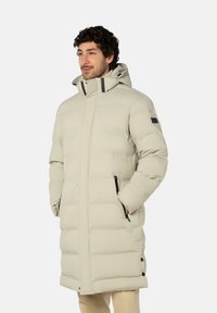 Lichtgrijze donsjas met capuchon, voorzien van een ritssluiting aan de voorkant, zijzakken en zwarte accenten op ritssluitingen en knopen.