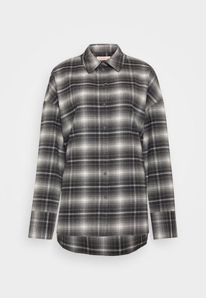 Chemise à manches longues à carreaux en noir, gris et blanc. Dotée d'une fermeture à boutons à l'avant, d'un col pointu et d'une coupe décontractée avec un ourlet droit.