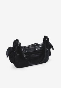 Bolso de mano de cuero negro con dos compartimentos con cremallera, textura suave, forma curva y asas cortas. Presenta un sutil detalle arrugado.
