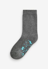 Chaussette en coton grise avec un bord côtelé et un motif de taches turquoise près des orteils. Texture douce et longueur standard jusqu'à la cheville.