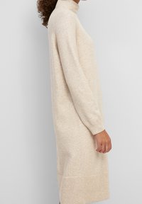Beige Strickkleid mit hochgeschlossenem Kragen, langen Ärmeln und geripptem Saum. Verfügt über eine weiche Textur und eine lässige Passform.
