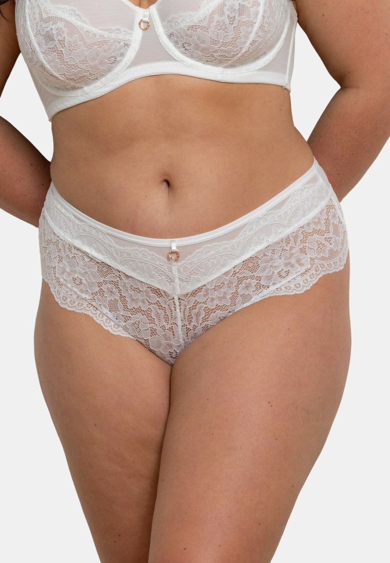 Culotte en dentelle blanche avec motif floral, dotée d'une bandeau doux et d'un accent en satiné central. Les côtés en mesh transparent améliorent la respirabilité.