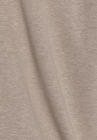 Svetle béžová bavlněná látka s hladkým, měkkým povrchem, obsahující jemný streč a jemný žebrovaný vzor po celé ploše.