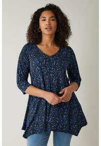 Schwarze Tunika mit V-Ausschnitt, die ein florales Muster in lila und grün aufweist. Hergestellt aus einem weichen Stoff, hat sie dreiviertel Ärmel und ein ausgestelltes Design.