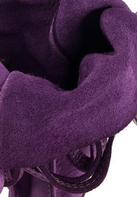 Close-up of a purple suede shoe showing textured upper with detailed stitching and laces on a white background.