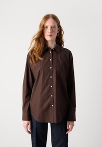 Brown button-up shirt with a classic collar, long sleeves, white buttons, and a front pocket, made from a smooth fabric.