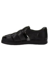 Sandali in pelle nera con design open-toe, multiple cinghie che attraversano il piede e superficie testurizzata. Suola in gomma robusta con leggera elevazione.