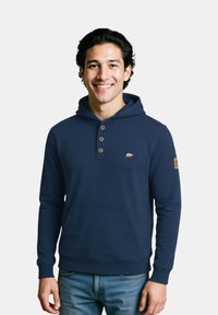 Felpa blu navy con tasca a marsupio, patta con tre bottoni e logo dell'orso. Presenta polsini e orlo a coste, realizzata in tessuto morbido.