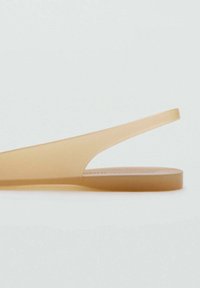 Translucent beige flip-flop with a minimalist design, featuring a narrow strap and flat sole. Smooth texture, lightweight material.