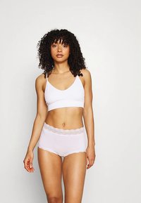 Bralette blanc à fines bretelles avec culotte taille haute assortie ornée de dentelle. Texture lisse, design simple et tissu doux.