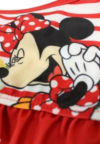 Tissu rayé rouge et blanc mettant en avant un personnage de dessin animé avec un nœud à pois. Texture lisse avec de forts accents de couleur noire et rouge.