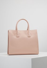 Różowa skórzana torba typu tote z dwoma uchwytami u góry, o wyraźnym prostokątnym kształcie, gładkiej fakturze i minimalnych detalach w szwie.
