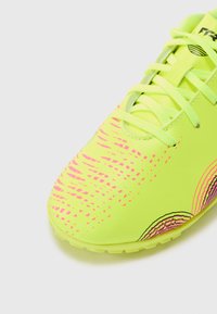 Baskets de sport jaune fluo avec surface texturée, motifs abstraits roses et lacets plats. Semelle en caoutchouc légère pour une meilleure adhérence.