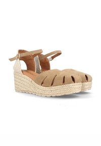 Las sandalias de cuña de ante en tono tostado presentan un diseño con recortes, una suela intermedia de yute tejido y una correa para el tobillo con acentos de hardware dorados.