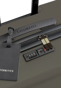 Dunkelgrüner Koffer mit einem Zahlenschloss, doppelt metallen Reißverschluss, einem schwarzen Ledergeschäftsanhänger und einem strukturierten Griff.