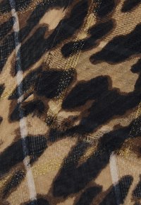 Leopardprint tekstil med et gennemsigtigt, let materiale med gyldne accenter og en struktureret overflade, der viser nuancer af brun, sort og creme.