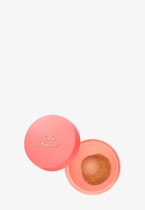 Geöffneter korallenrosa Kompaktpuder von Too Faced Bronzer mit losem braunem Puder und geprägt gewölbtem Zentrum auf weißem Hintergrund.