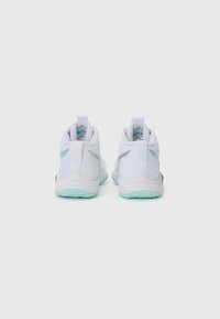 Chaussures de sport blanches à la texture lisse, avec une semelle extérieure vert clair, des accents gris et une languette au talon pour un enfilage facile.