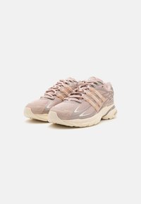 Scarpe da ginnastica rosa chiaro in materiale mesh e sintetico, con tre strisce color tan, dettagli bianchi e suola beige.