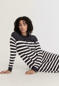 Gestreiftes Sweatkleid in Marineblau und Creme, mit langen Ärmeln, gerippten Bündchen und einer lockeren Passform, die auf ganzer Länge horizontale Streifen aufweist.