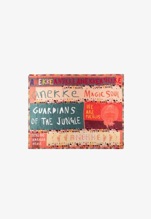 Tessuto colorato con le parole "Anekke," "Magic Soul," "Guardians of the Jungle," "We Are Pueblos," e "Strong Warrior Brave" con una piccola illustrazione del personaggio.
