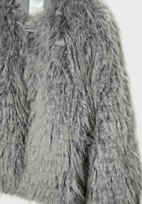 Sivá umelá kožušina s chlpatou textúrou a skráteným dizajnom. Obsahuje mäkké, dlhé vlákna, ktoré vytvárajú objemný vzhľad.