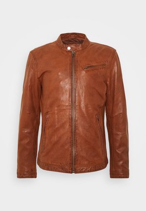 Chaqueta de cuero marrón con cuello alto, cremallera frontal y bolsillo con cremallera vertical en el pecho. Textura suave y diseño ajustado.