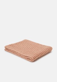 Manta rosa trançada com um padrão texturizado em grade, dobrada de forma organizada. Material suave com uma aparência acolhedora.
