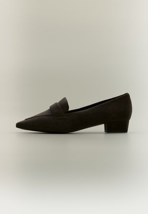 Mocassin femme noir à petit talon avec bout pointu et large bride sur le dessus, présenté sur un fond clair uni.