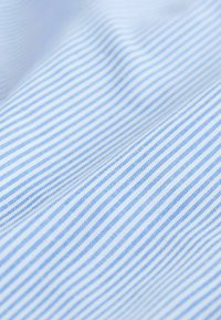 Jasnoniebieska tkanina z wąskimi białymi paskami, charakteryzująca się gładką fakturą i miękkim układaniem. Cały wzór jest subtelny i równomiernie rozmieszczony.