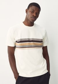 T-shirt da uomo a maniche corte color crema chiaro con motivo a righe orizzontali in grigio, marrone e beige. Realizzata in tessuto morbido con scollo rotondo.