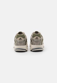 Zapatillas deportivas en gris y verde oliva, con materiales de malla y sintéticos, que cuentan con una suela acolchada, punta redonda y detalles de marca.