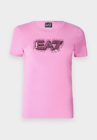 Růžové bavlněné tričko s krátkým rukávem a kulatým výstřihem. Na přední straně se nachází flitrové logo "EA7" v kontrastních barvách.